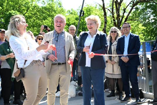 Foto wie Deniese Errass-Gurtner, Jean-Michel With und Thekla Huber das rote Band durchshneiden.